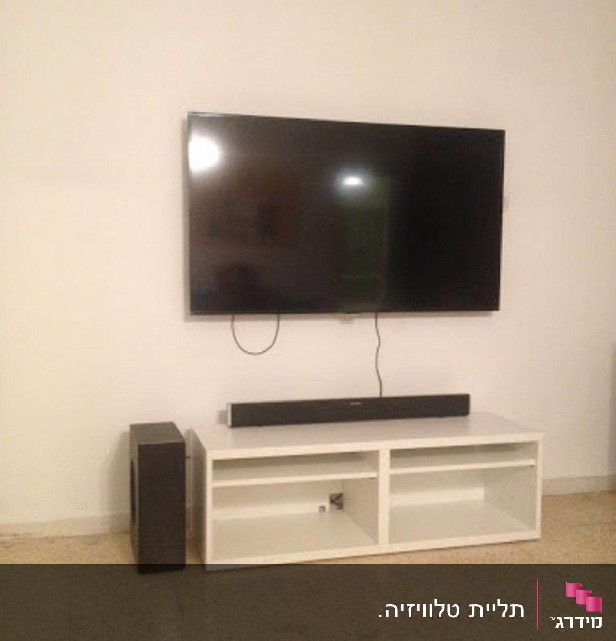 טלוויזיה תלויה על הקיר עם כבלים גלויים